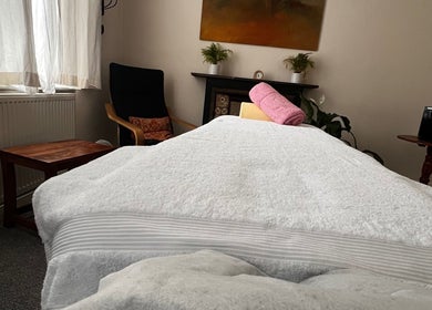 Cozy massage room at Her Sanctuary Holistic Therapies in Leeds, England, GB with soft lighting and decor.