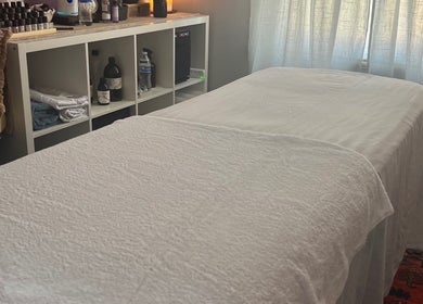 Cozy treatment room with a bed at Her Sanctuary Holistic Therapies, Leeds, England, GB.