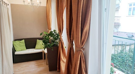 Elegantní interiér Kosmetika Helena Kramářová, Hlavní Město Praha, s pohodlnou pohovkou a závěsy.