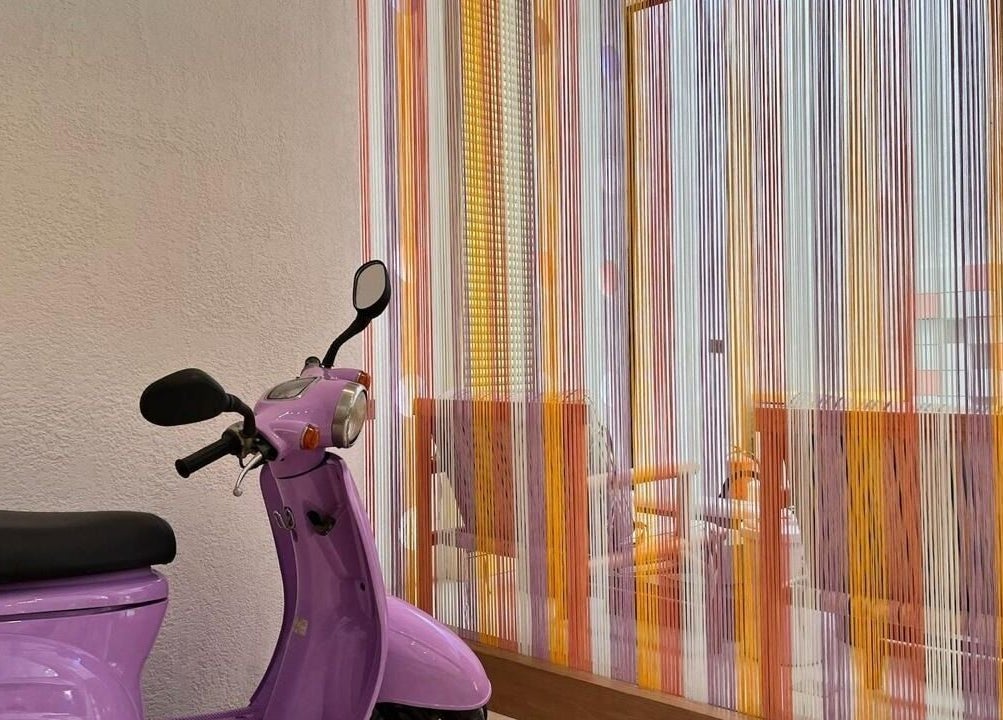 Purple scooter by colorful strings at Lapalma boutique, Riyadh, Riyadh Province, SA.