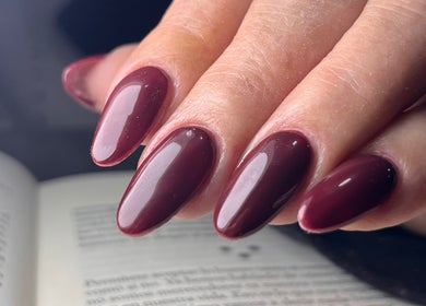 Manicura burgundy brillante en Marianela Romero, San Juan, San Juan, AR, destacando elegancia y estilo.
