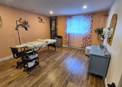 Salle de soins à LaPointe Des Cils, Sainte-sophie, Québec, CA, avec table de massage et décor chaleureux.