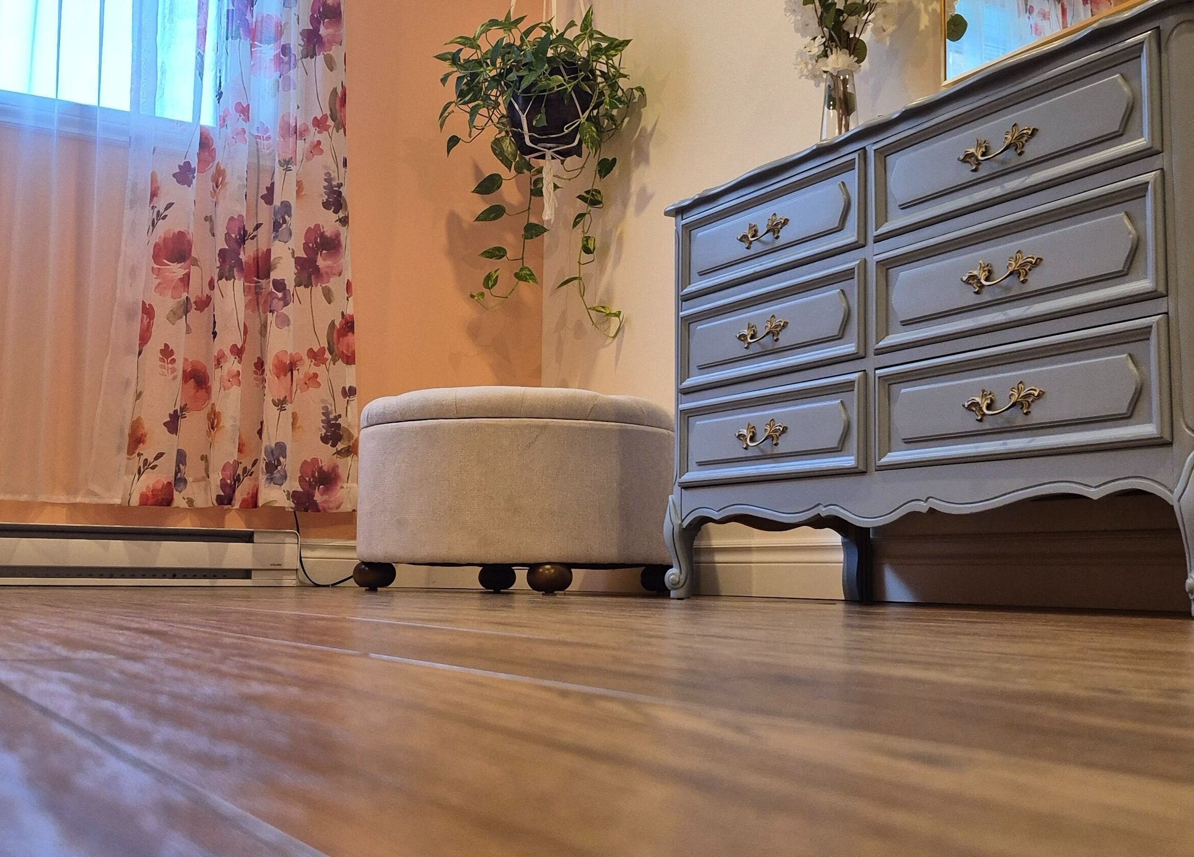 Intérieur apaisant de LaPointe Des Cils à Sainte-Sophie, Québec, CA avec rideaux floraux et commode élégante.