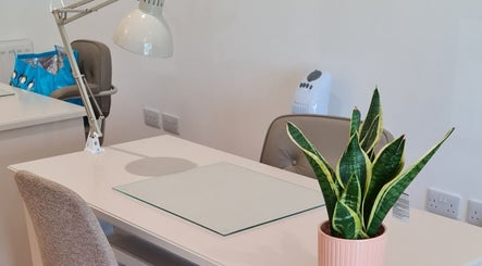 Modern nail salon workspace at Nails by Claire in Par, England, GB with a sleek desk and plant decor.