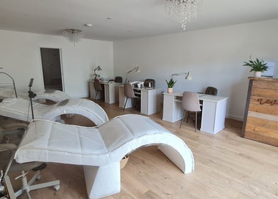 Bright, modern interior of Nails by Claire, Par, England, GB with manicure stations and comfy chairs.