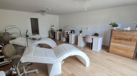 Bright, modern interior of Nails by Claire, Par, England, GB with manicure stations and comfy chairs.