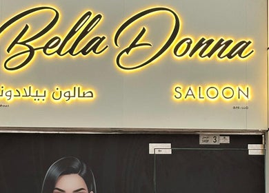 Bella Donna Saloon in Ajman, AE, sign warmly illuminated with striking elegance at entrance.