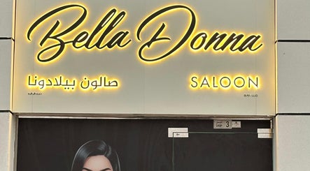 Bella Donna Saloon in Ajman, AE, sign warmly illuminated with striking elegance at entrance.