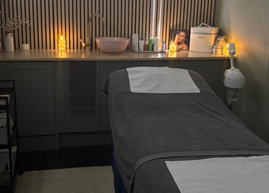 Relaxing treatment room at Bare Beauty Nails, Caerphilly, Cymru, GB, with a comfortable, candle-lit massage bed.