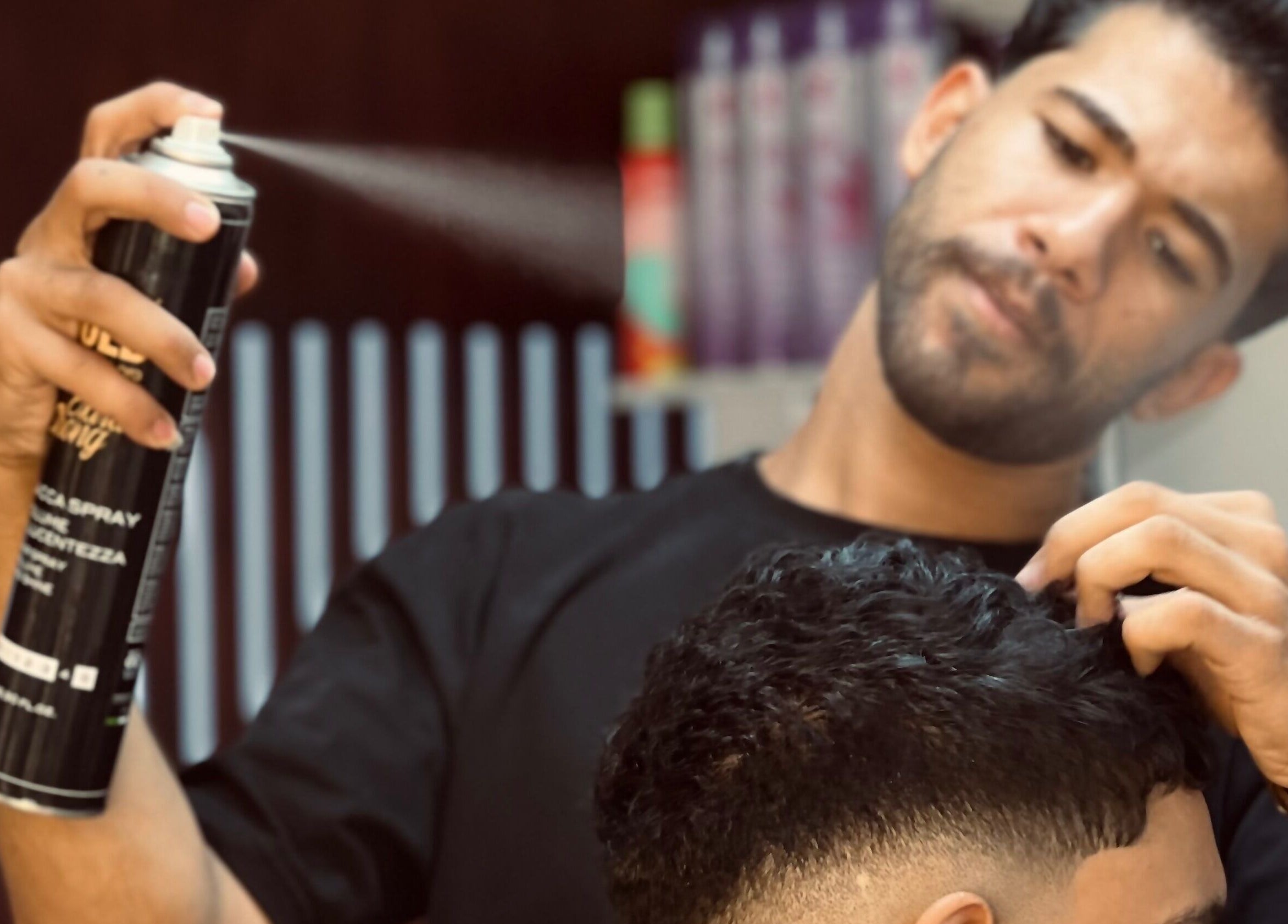 حلاق في 'نعم حلاق' يضع رذاذ شعر على زبون بشارع الصحبجية، EG.