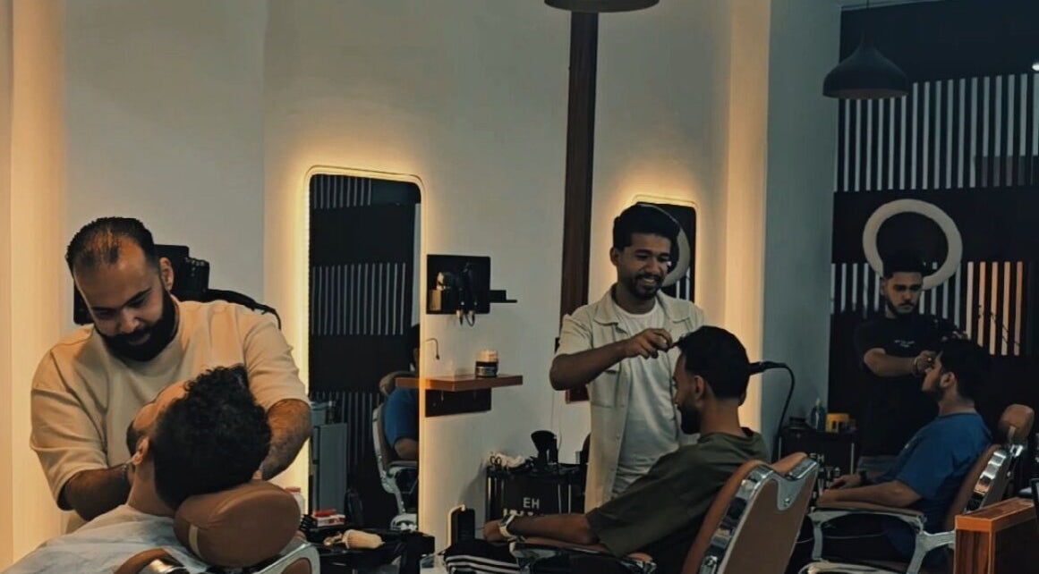 حلاقين يعملون في صالون Yes a barber بشارع الصحبجية, EG، يقدمون خدمات تصفيف متميزة.