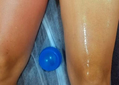 Tratamento de massagem nas pernas em Massagem Relax Faro, Faro, PT, com ventosa azul e óleo revitalizante.