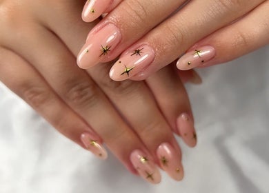 Decoración de uñas con estrellas doradas en Jess Beauty Studio, St. Catharines, Ontario, CA.