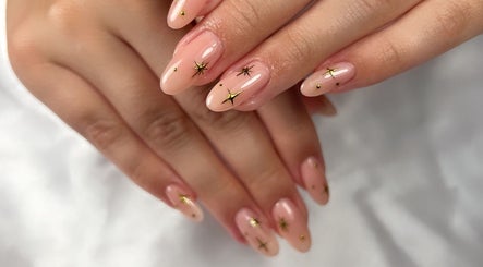 Decoración de uñas con estrellas doradas en Jess Beauty Studio, St. Catharines, Ontario, CA.