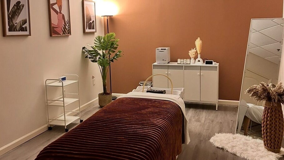 Lashes Forevermore spa room in Hiram, Georgia, US features cozy decor with a massage table and warm lighting.