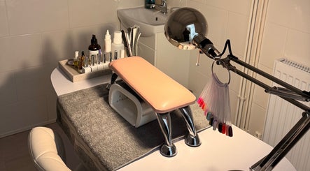 Manicure station at Nailcita Bysim in Hornchurch, England, GB, featuring tools and a pink armrest.