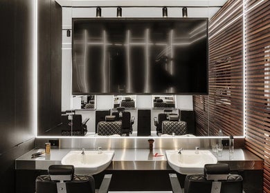 Modern salon interior at Hdcutz Leo, London, England, GB, showcasing sleek styling stations and mirrors.