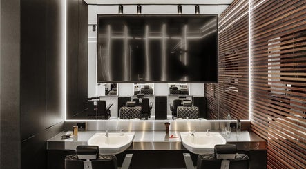 Modern salon interior at Hdcutz Leo, London, England, GB, showcasing sleek styling stations and mirrors.