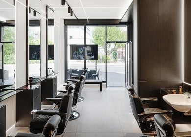 Modern interior of Hdcutz Leo in London, England, GB, featuring sleek barber chairs and minimalist design.