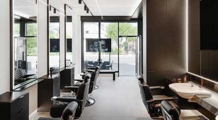 Modern interior of Hdcutz Leo in London, England, GB, featuring sleek barber chairs and minimalist design.