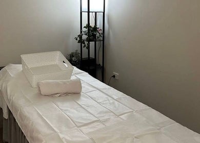 Agape Massage，位于澳大利亚西澳Beldon的舒适按摩房间，白色床单和植物装饰。