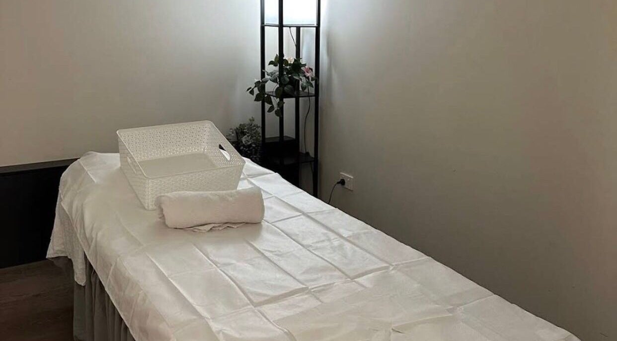 Agape Massage，位于澳大利亚西澳Beldon的舒适按摩房间，白色床单和植物装饰。