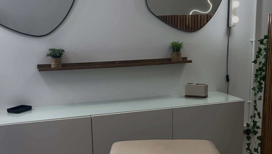 Modern vanity at Emma Pollock Makeup in Clydebank, Scotland, GB with mirrors and greenery decor.