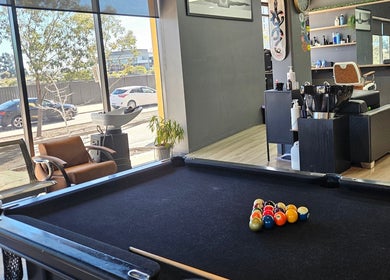 Lux Barbershop in Cockburn Central, Western Australia, features a pool table beside modern barber chairs.