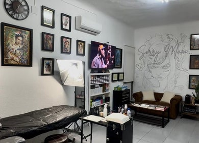 Interior del MRGRAPHICAS TATTOO STUDIO en Córdoba, Andalucía, ES, mostrando decoraciones y área de trabajo.
