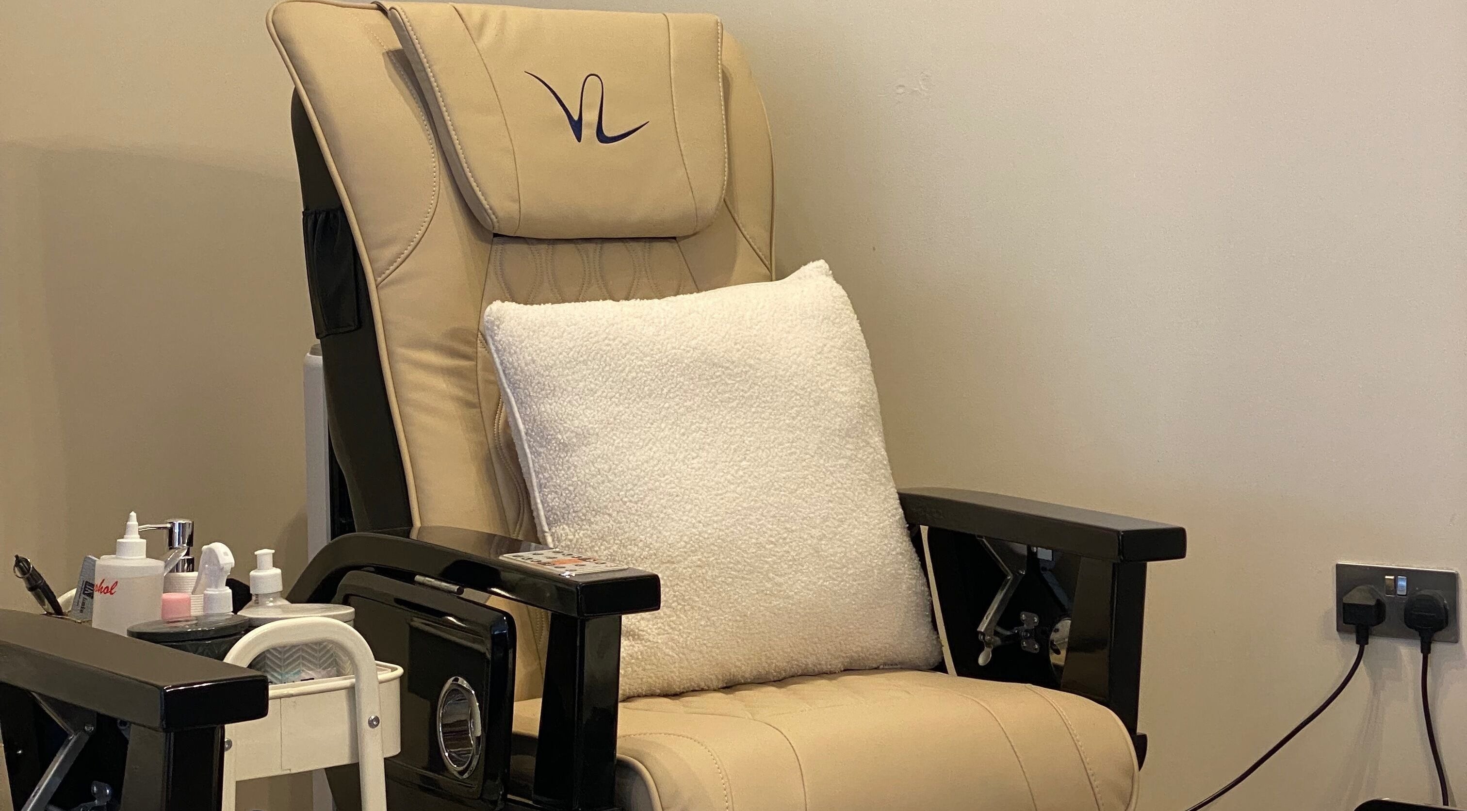 Cozy pedicure chair at Nhi's Nails, Truro, England, GB, with plush pillow and nail supplies.
