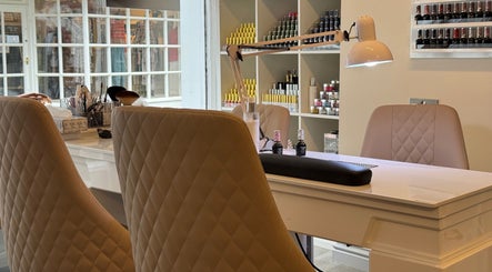 Elegant manicure station at Nhi's Nails in Truro, England featuring sleek chairs and organized nail polish displays.
