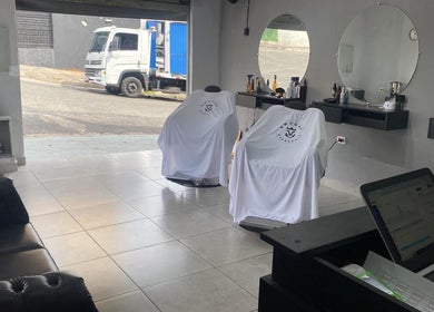 Interior da BARBEARIA EMUNÁH em São Paulo, São Paulo, BR, mostrando poltrona e espelhos elegantes.
