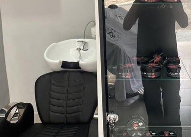 Cadeira de barbeiro moderna na BARBEARIA EMUNÁH, São Paulo, São Paulo, BR, com produtos estilizados.