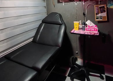 Relaxed tattooing setup at Needle Narratives, Cebu City, Central Visayas, PH showing a black chair and tools.