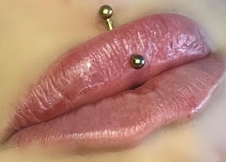 Close-up of a lip piercing with glossy finish at Clcosmeticsxo, Bristol, England, GB.