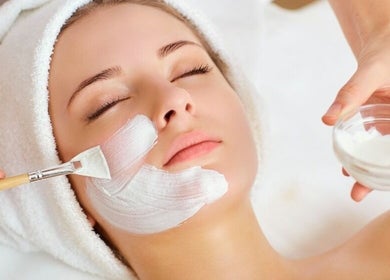 Woman receiving facial treatment at Magic Box Beauty, London, England, GB, highlighting relaxation and skincare.