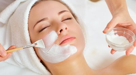 Woman receiving facial treatment at Magic Box Beauty, London, England, GB, highlighting relaxation and skincare.