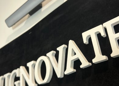 Close-up of WIGNOVATE sign at Ocho Rios, JM, showcasing elegant white lettering on a dark background.