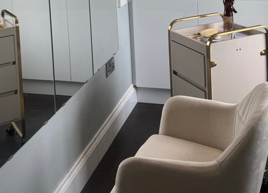 Stylish salon interior at The Tape Studio, Huddersfield, England, GB with a plush chair and sleek mirrors.