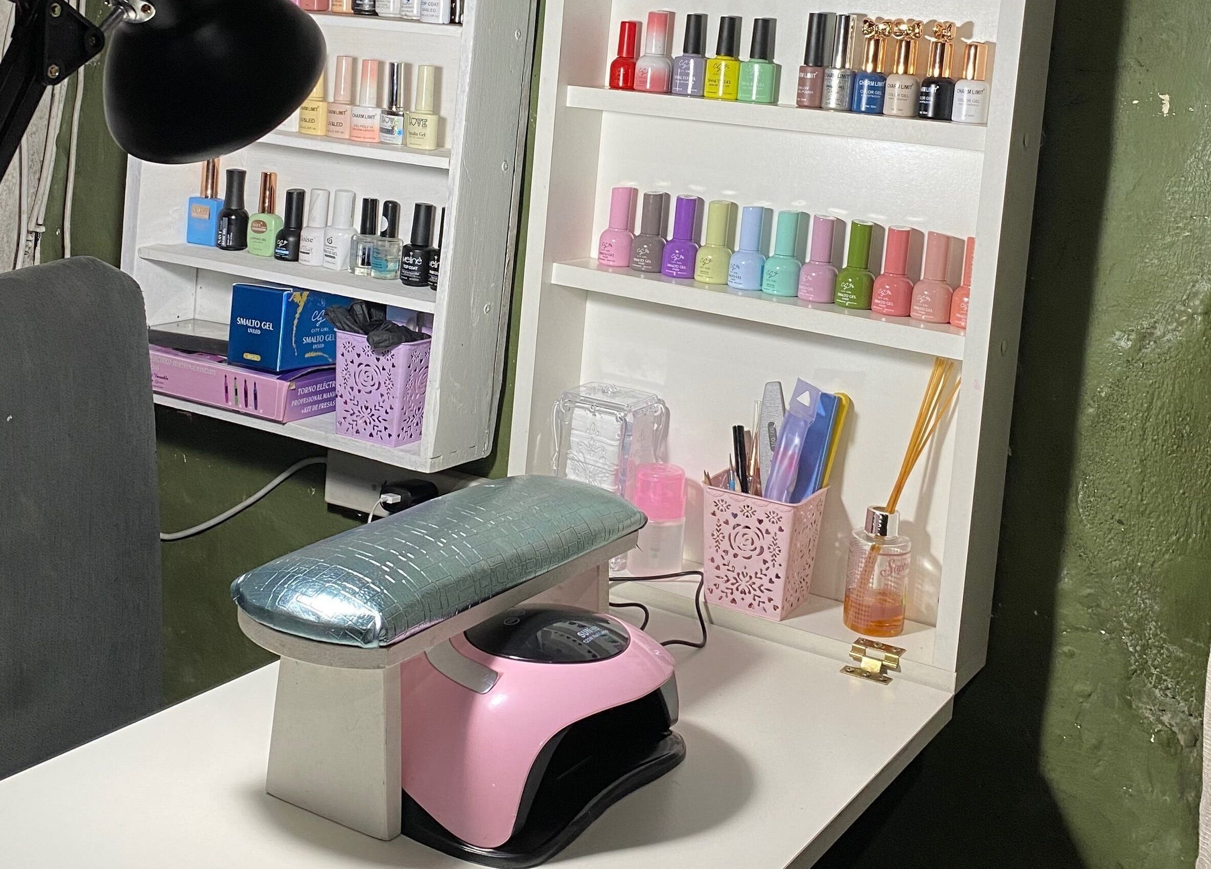 Estación de manicura en Cherie Nails, 9 De Julio, Provincia De Buenos Aires, AR, con esmaltes y lámpara UV.