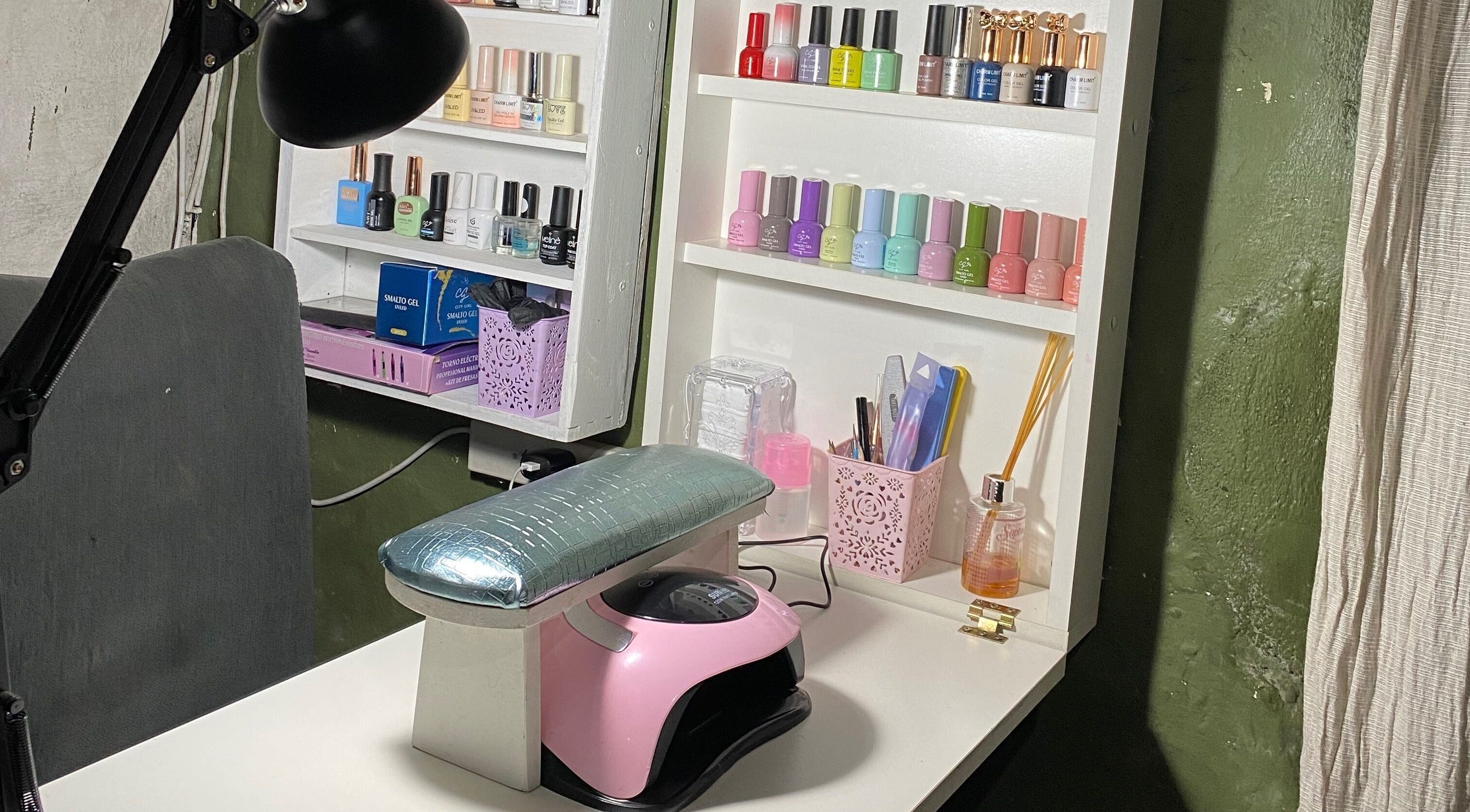 Estación de manicura en Cherie Nails, 9 De Julio, Provincia De Buenos Aires, AR, con esmaltes y lámpara UV.