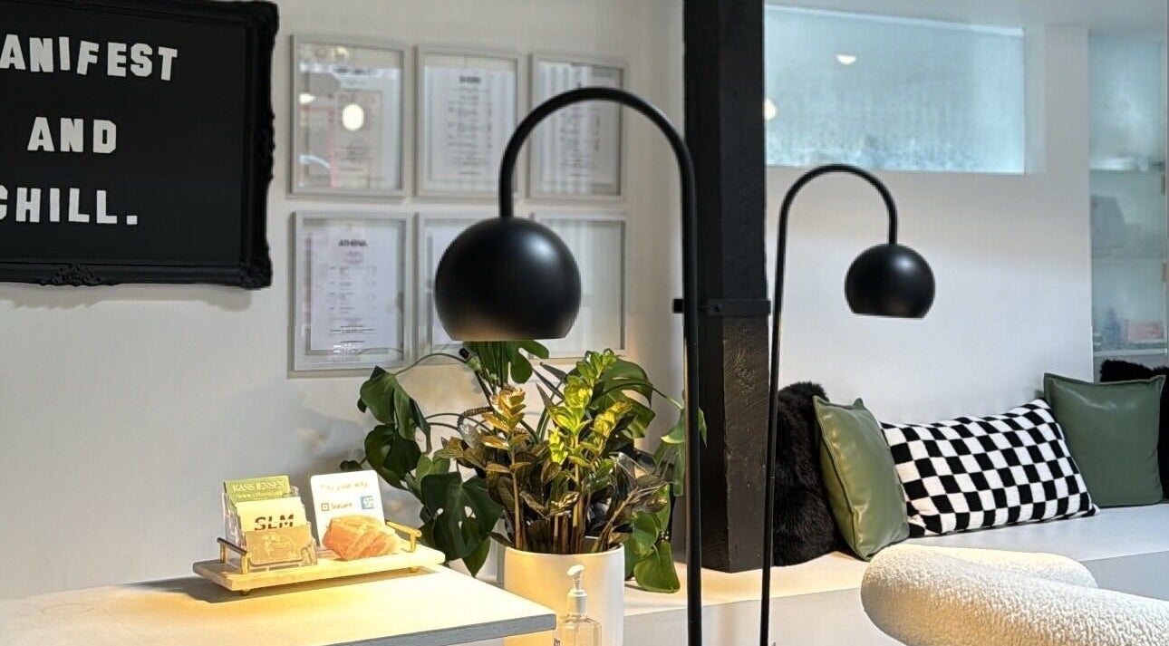 Inviting lounge at Diveyen Lash, Ottawa, CA with modern decor and lush plants.