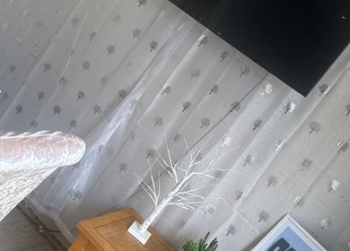 Elegant decor at SWbeautyx, Dunmow, England, GB featuring a white tree sculpture and patterned curtain.