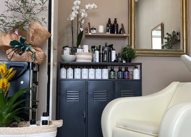 Interior de Salón Orgánico Ana Blanco en Santander, Cantabria, ES con productos y silla blanca.