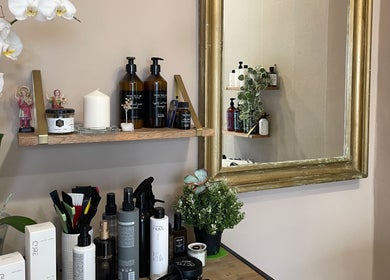 Productos de belleza en Salón Orgánico Ana Blanco, Santander, Cantabria, ES, reflejados en un espejo dorado.