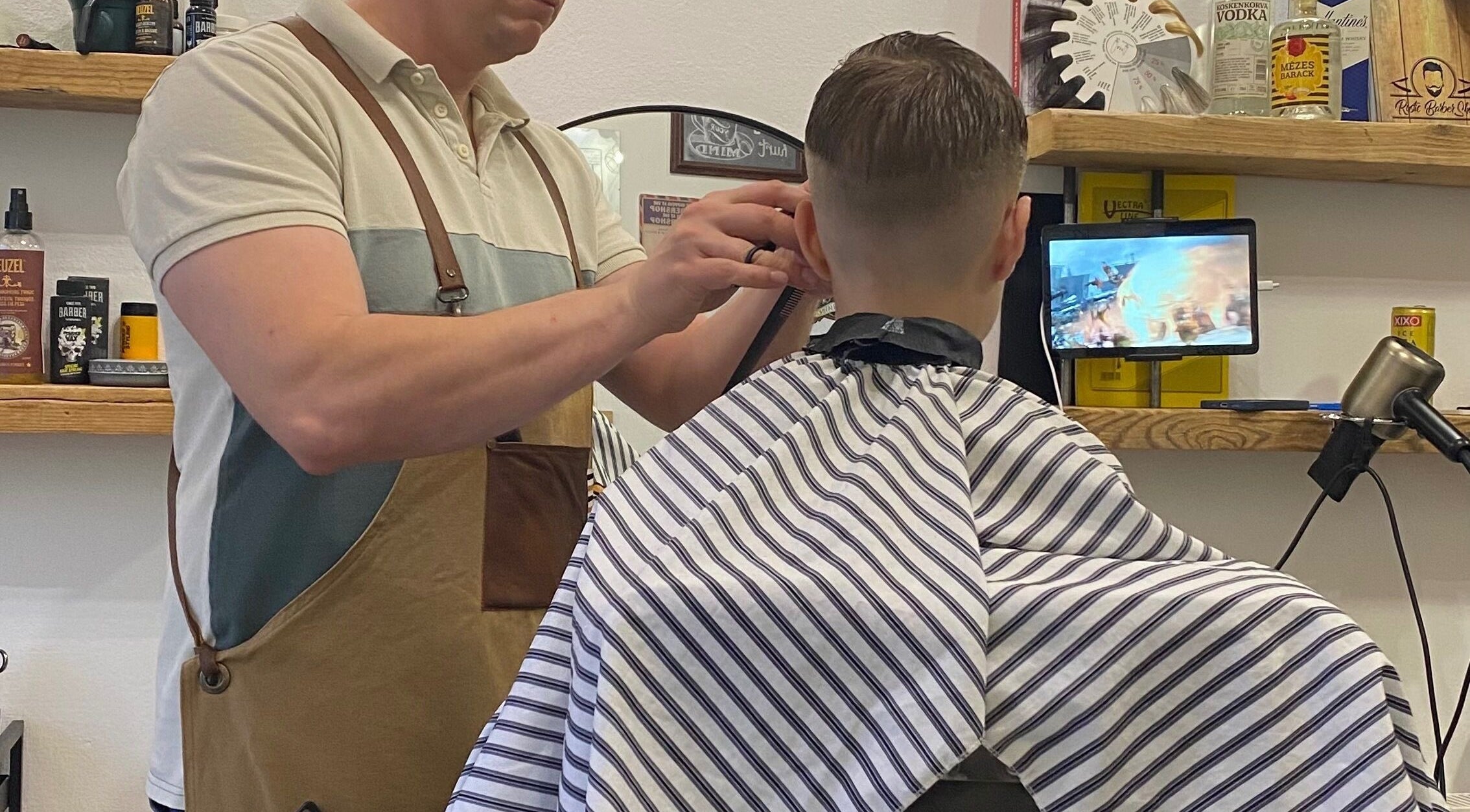 Borbély készíti a férfi frizurát a Rustic BarberShopban, Felsőtárkány, HU.