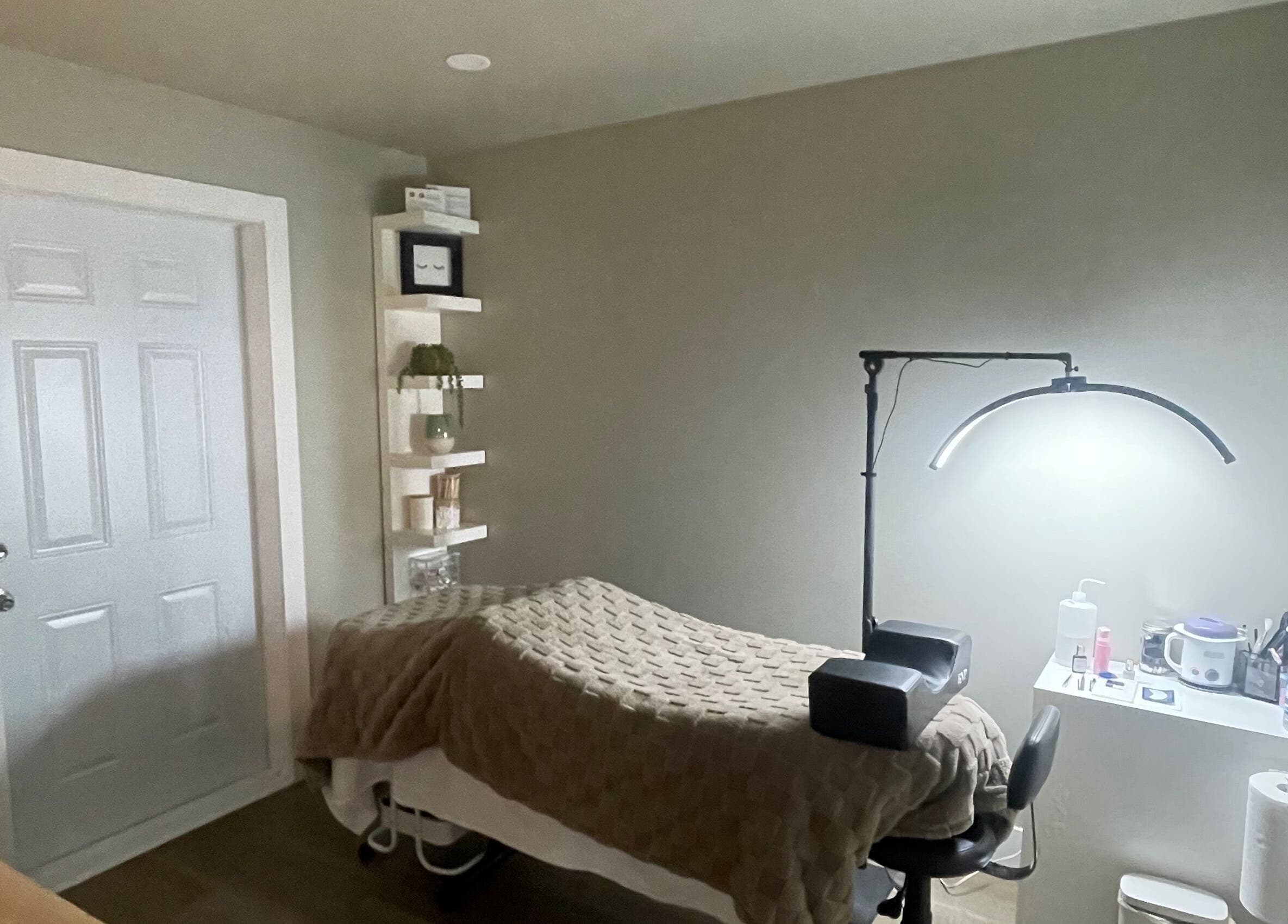 Cozy treatment room at Chelseas Esthetics in Sydney Mines, Nova Scotia, CA, featuring a massage bed and soft lighting.