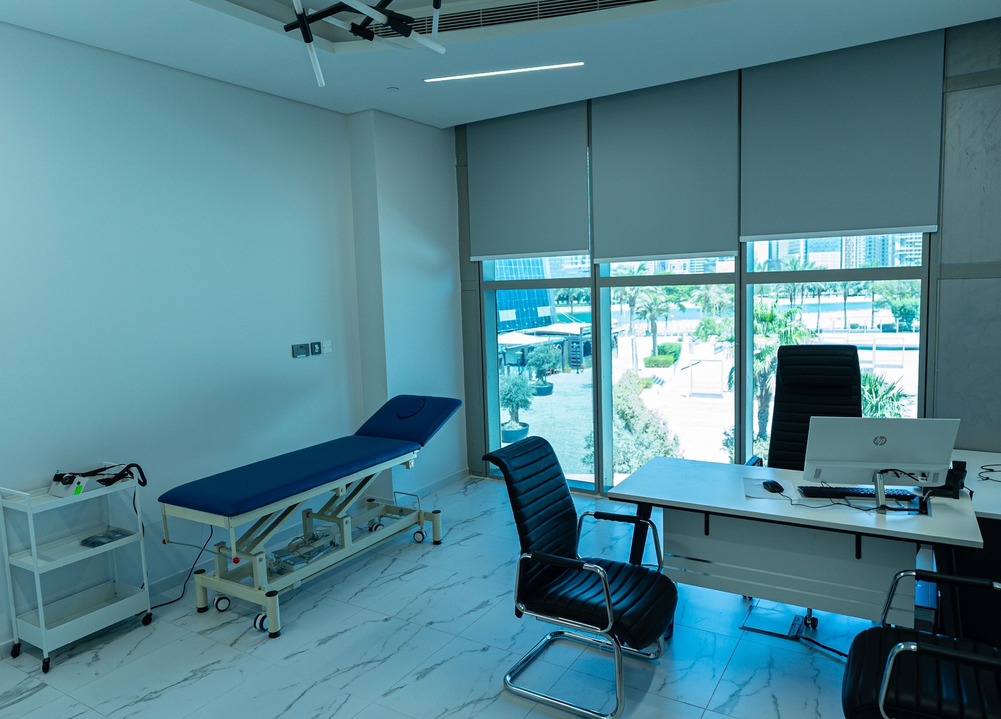 Modern clinic room at Boulevard Clinic, Doha, Doha Municipality, QA, with desk and examination bed.