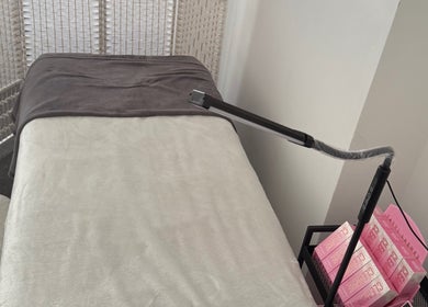Cozy treatment bed at Lala’s Luxe Beauty in Maidstone, England, GB, ready for relaxation.