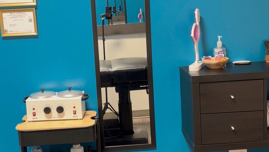 Clean and modern treatment room at Glow With Lindsay in Chicago, Illinois, US, featuring a waxing station.